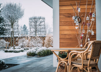 Taras zimą z meblami ogrodowymi i zaśnieżoną ławeczką angi