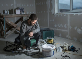 mężczyzna obsługujący agregat malarsko-szpachlarski